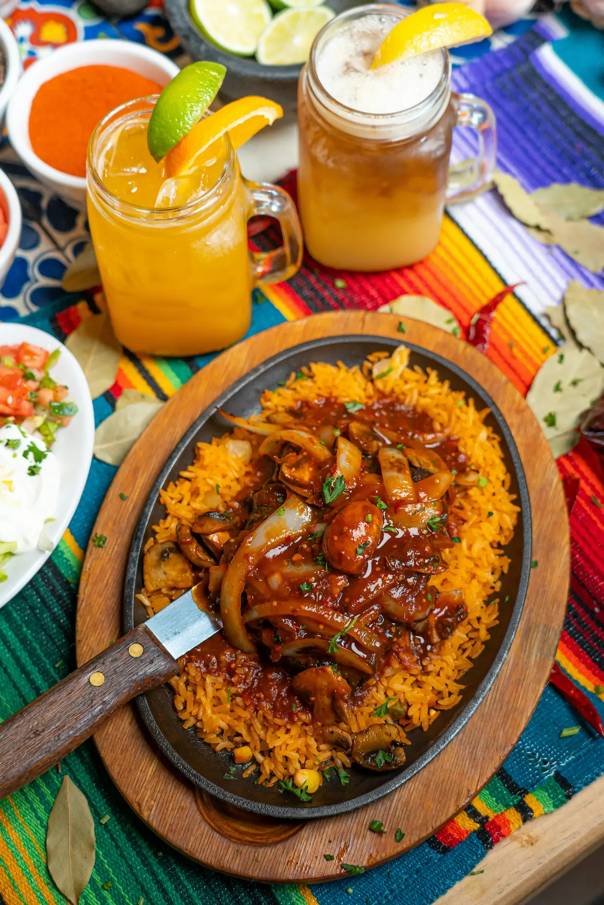 Sizzling fajitas on a cast-iron skillet over Mexican rice